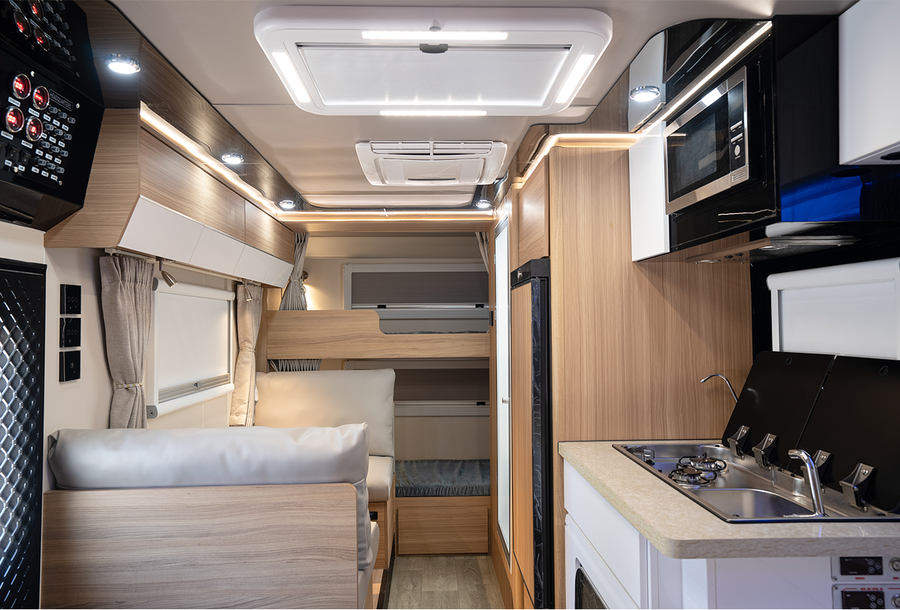 HQ17 full cabin view with kitchen, dining seats and rear bunks