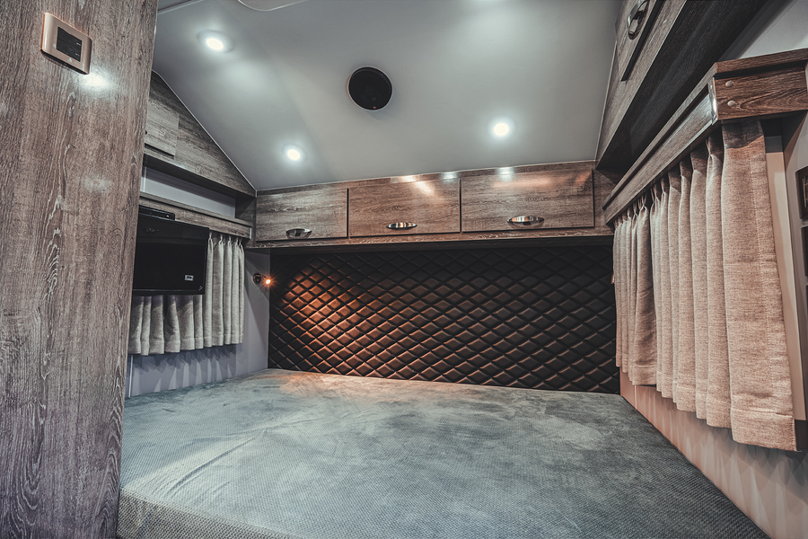 TH-series main sleeping area with upholstered headboard, side window and overhead storage